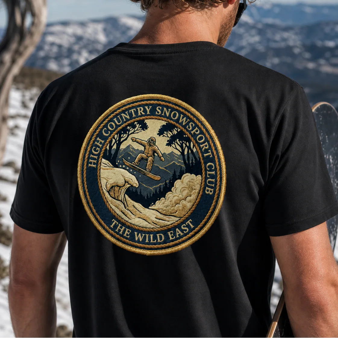 Black organic tee, back print of skier badge with text “The Wild East”